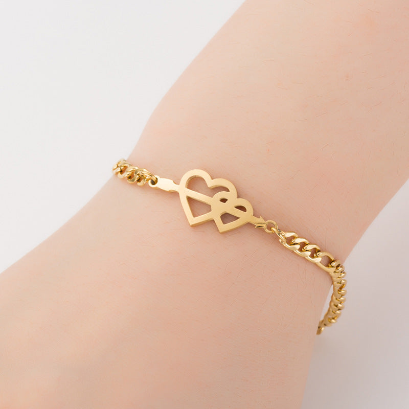 Um braço feminino mostrando a pulseira aço inox com corações