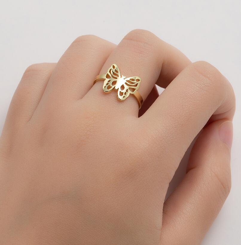 Uma mão usando anel borboleta de aço inox